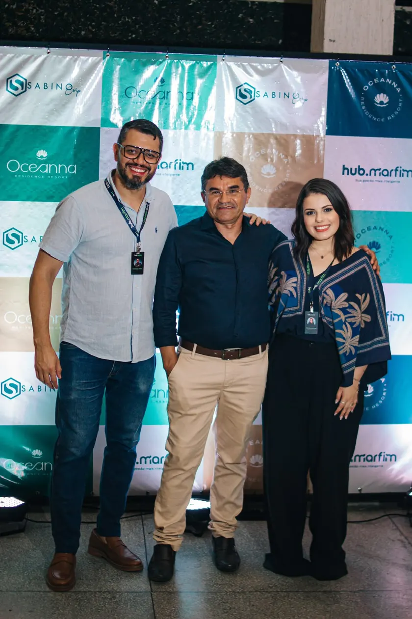 Melyssa Martins ao lado de parceiros no estande de um lançamento