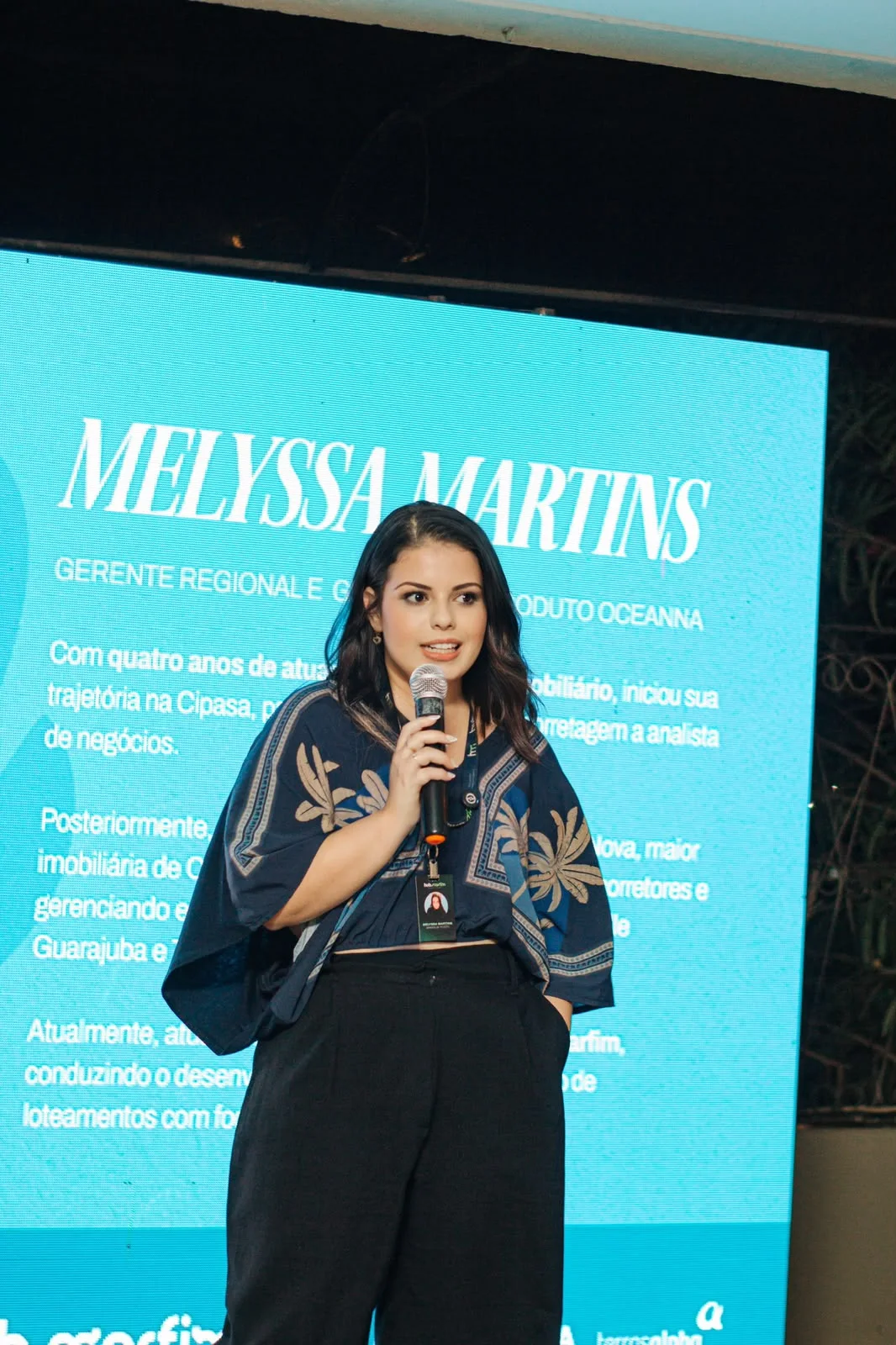 Melyssa Martins apresentando uma estratégia comercial no palco